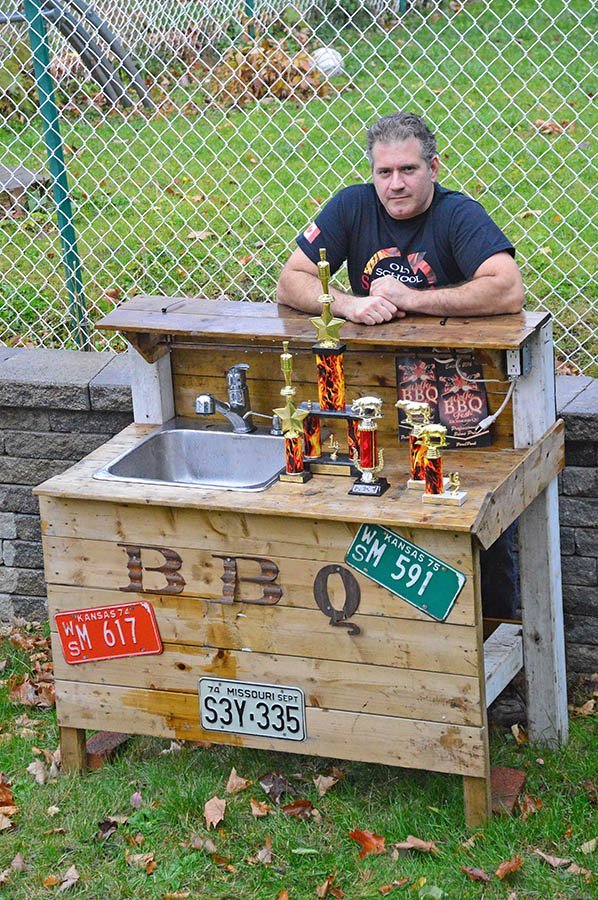 Manny Mavroudis with some of the trophies he’s won in BBQ and smoking competitions
